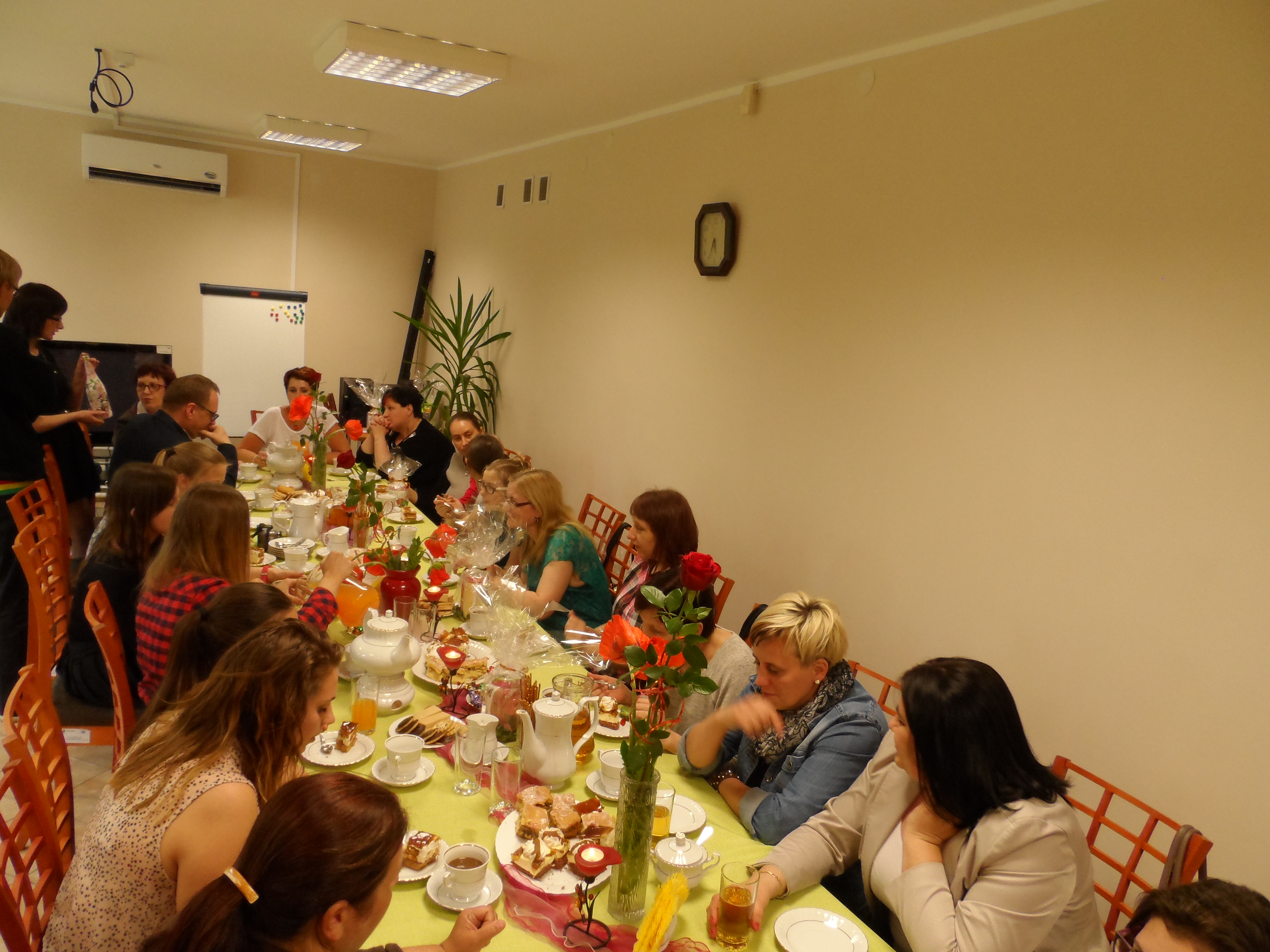 Goście spotkania z okazji Dnia Mamy przy stole z poczęstunkiem